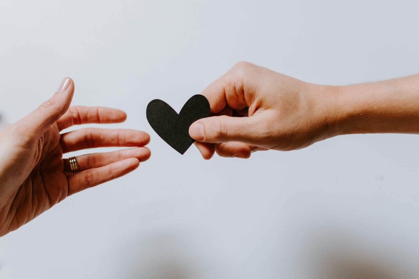 Woman passing the heart of kindness to another woman