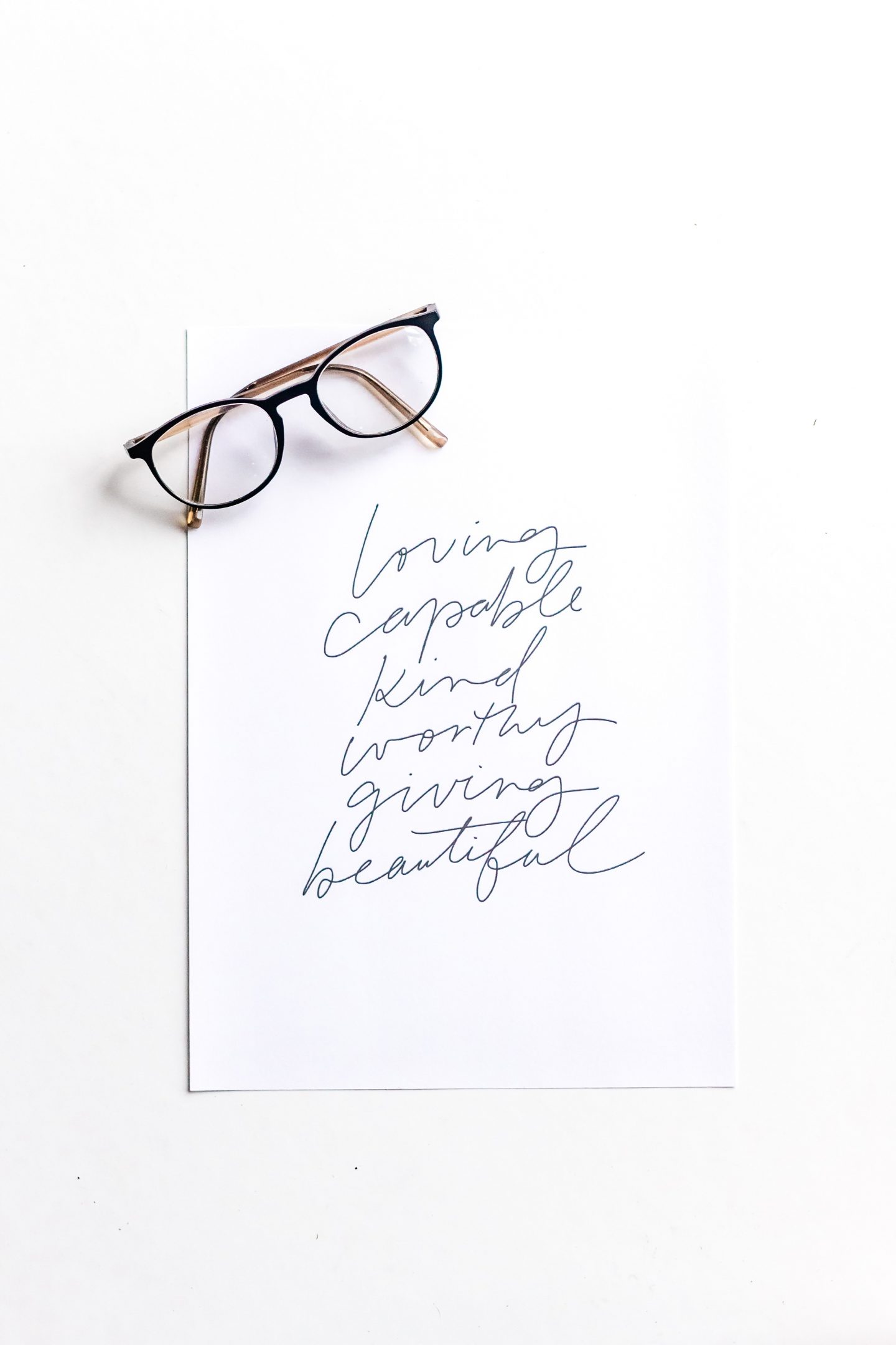 Life affirming words written on paper with a pair of glasses